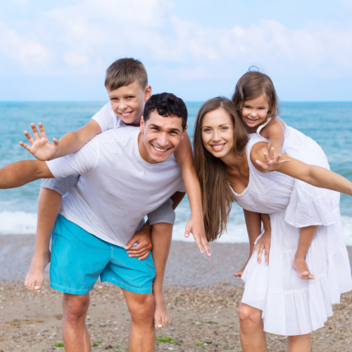 a man and woman with children on a beach